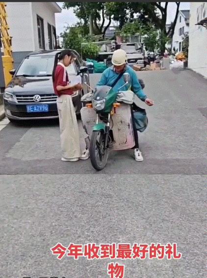 一快递员为女生送来高考录取通知书，而女生下来拿通知书时，为了分享自己这份金榜题名