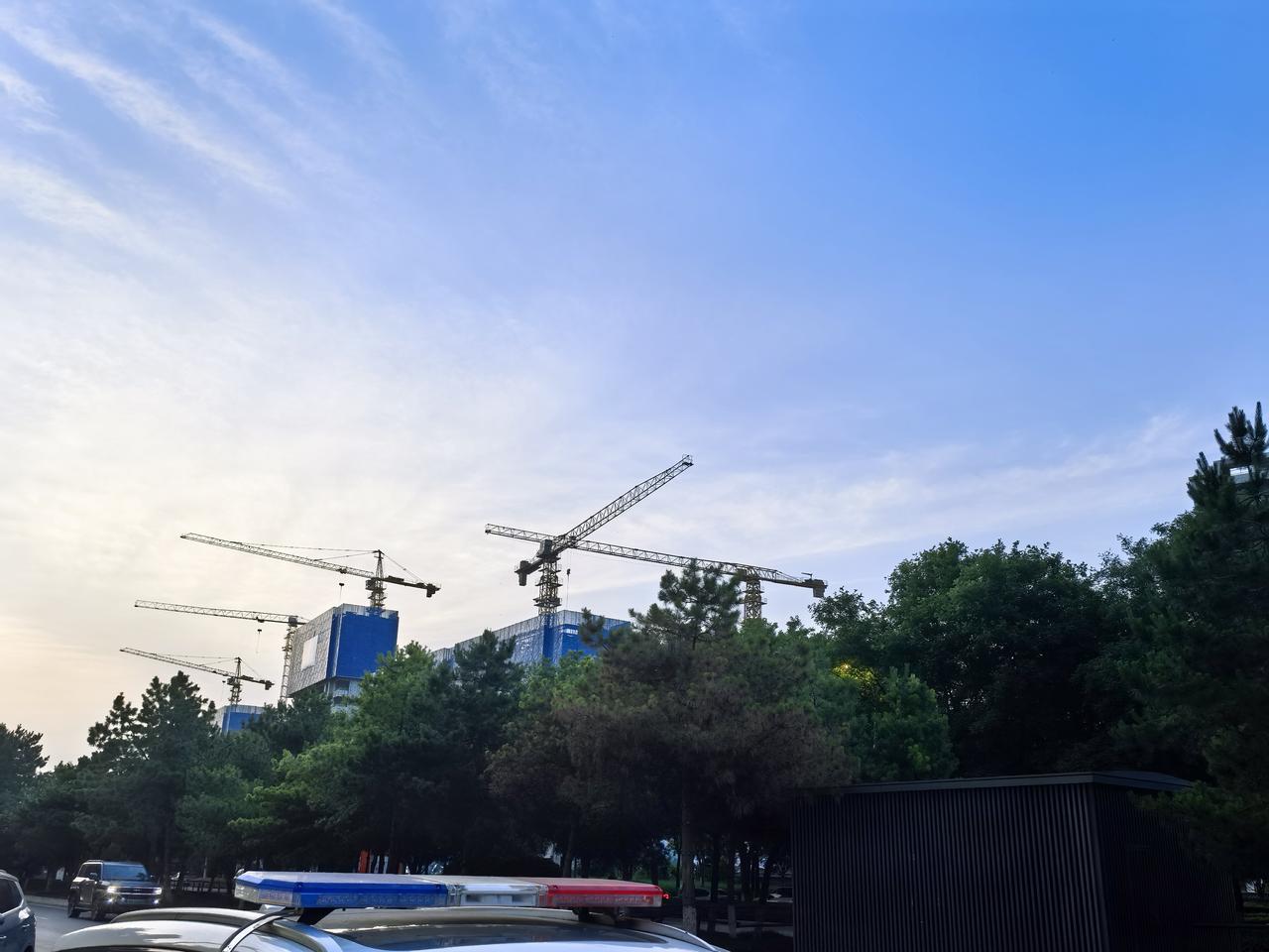 塔吊正举着落日的余晖，在蓝丝绒般的天空写着诗。原来最硬核的建设，也藏着时间美学。