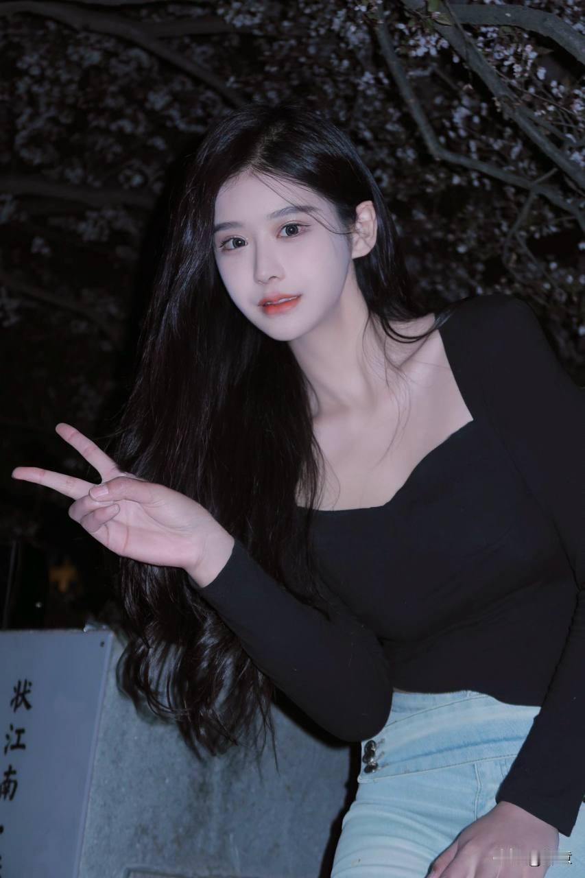 夜色樱花下，黑衣少女俏皮比耶，温柔笑意藏不住，江南夜色美如画。