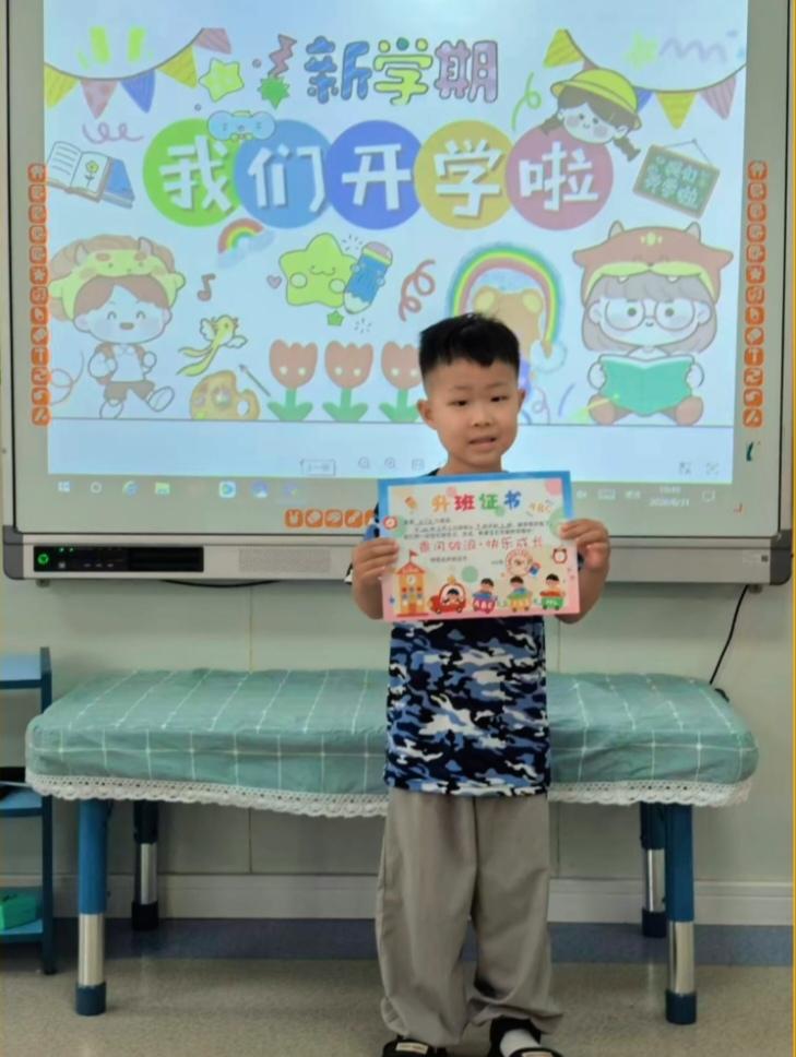 新学期开学啦，小宝贝孙子顺利从中班升到幼儿园大班。
小家伙捧着升班证书，满脸藏不