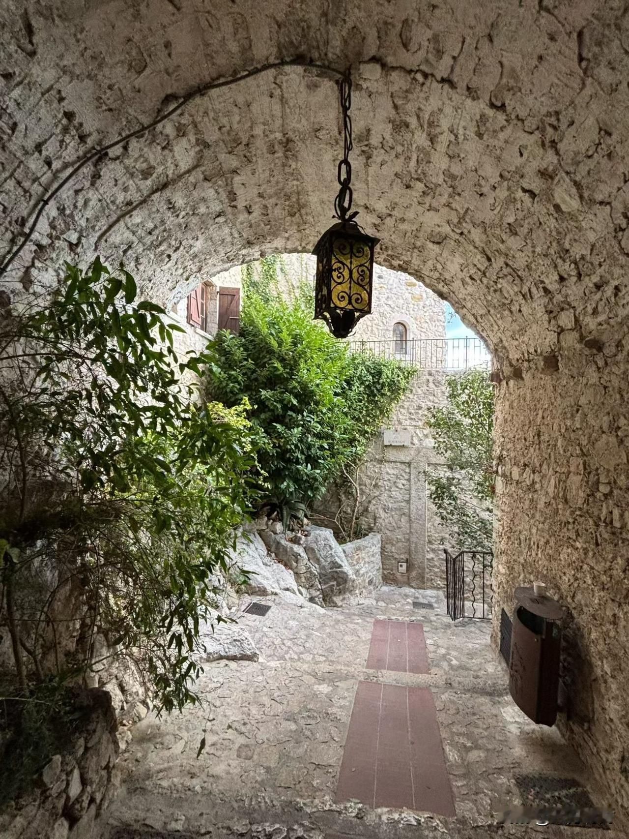最喜欢这欧洲中世纪风格的石拱巷道：

粗糙的碎石拱壁布满岁月纹理，铁艺吊灯垂挂其