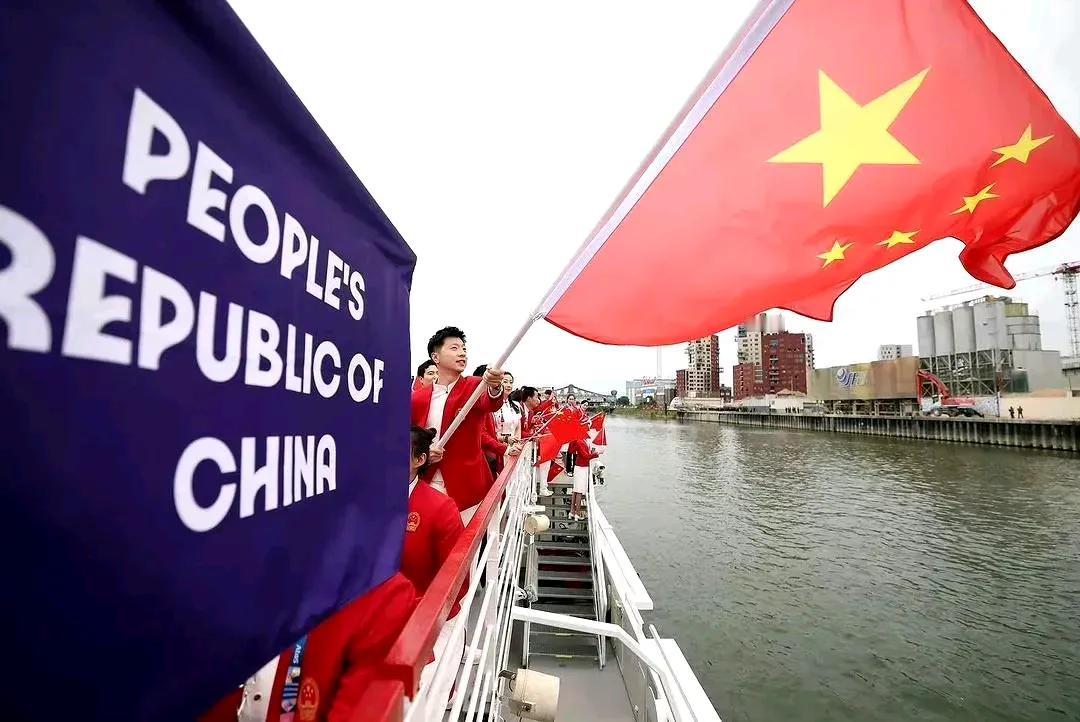 巴黎奥运会开幕式，各国代表团乘船巡游，中国代表团由乒乓球运动员马龙及花样游泳运动