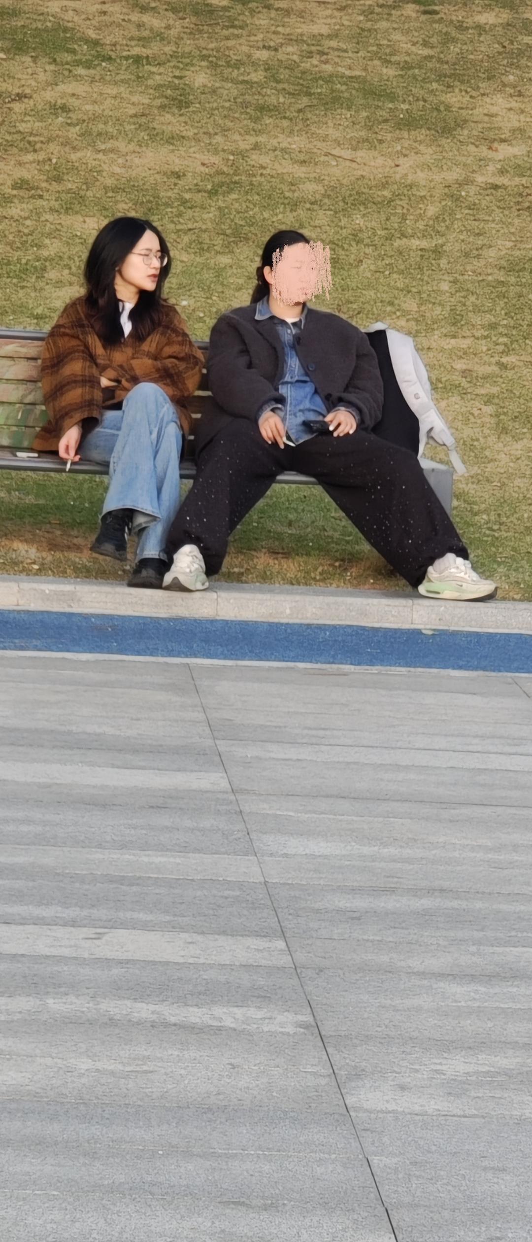 两个妙龄女孩，抽着烟就赚流量了。这有形无声的姿势比较，更让人无话可说。这里是公共