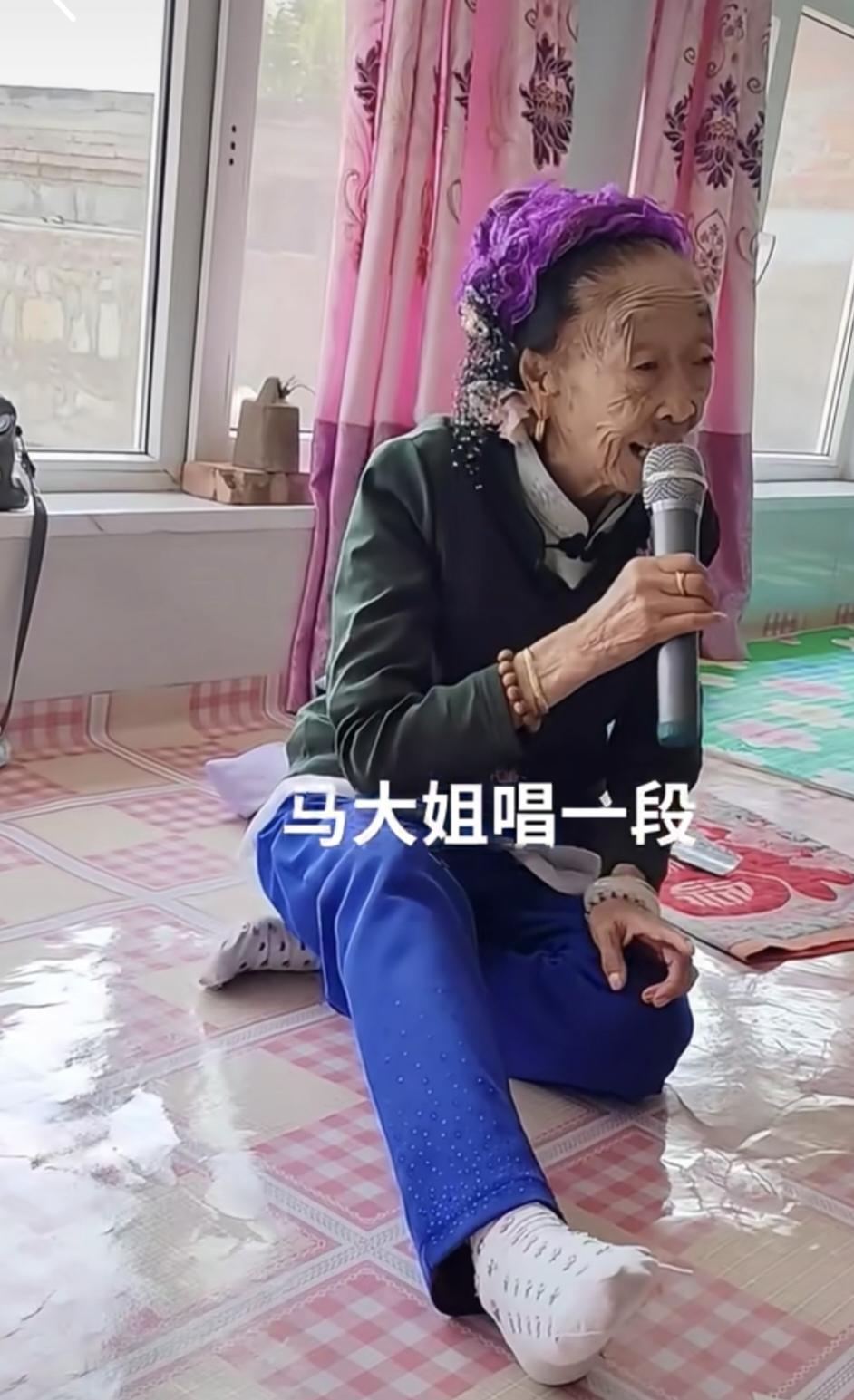 新潮啊，马玉琴坐在农村的火炕上，看看这个打扮，墨绿立领小袄，天蓝色裤子，头上戴着