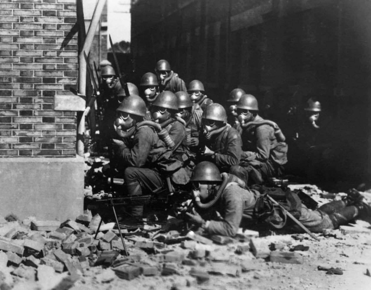 1937年，上海。佩戴防毒面具的日本海军特别陆战队士兵，在废墟中准备发起进攻。 