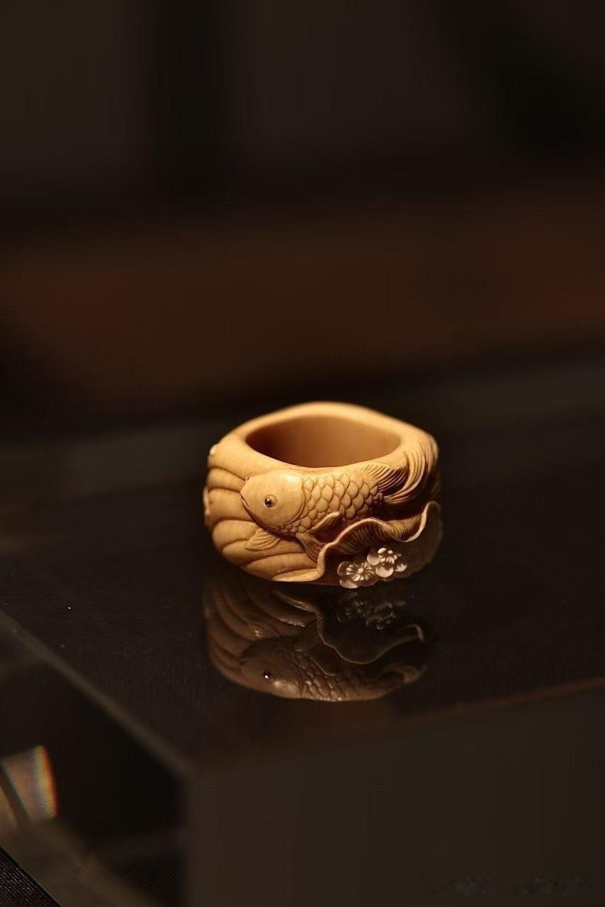 方寸之间，自有鱼跃花开的生机。

以锦鲤为题，繁花为景，浮雕层层铺展于一枚扳指之