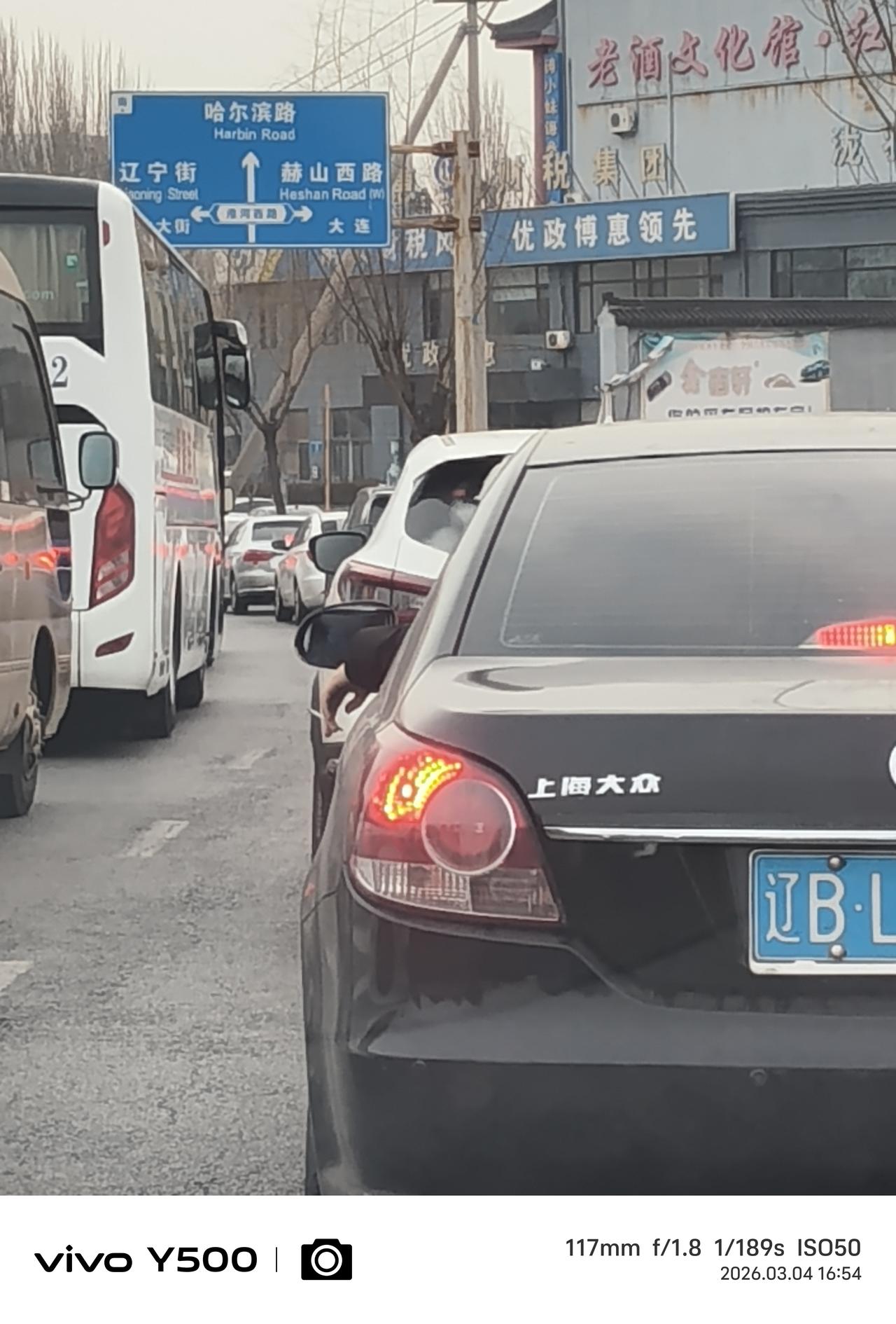 一边开车一边抽烟，而且右手扶方向盘左手夹着烟伸到车窗外面磕烟灰。
     自己