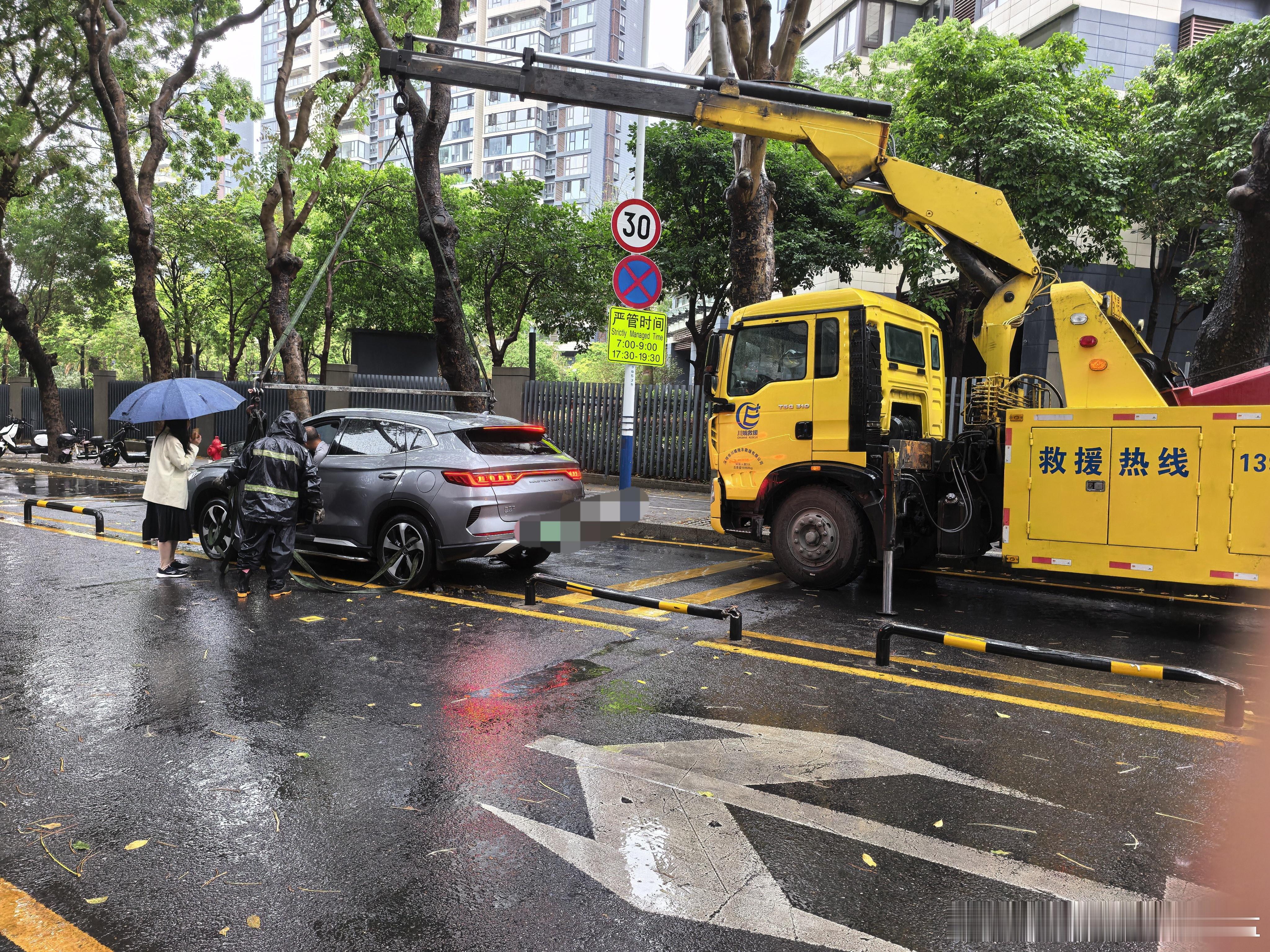 这就尴尬了，女司机把车开进了防护栏里，只能出动吊车来调离下雨天马上到下班高峰期，