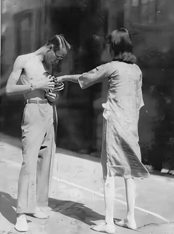 这是溥仪与婉容在天津寓居时的罕见留影，赤膊的溥仪正攥着物件，婉容伸手去抢。

照