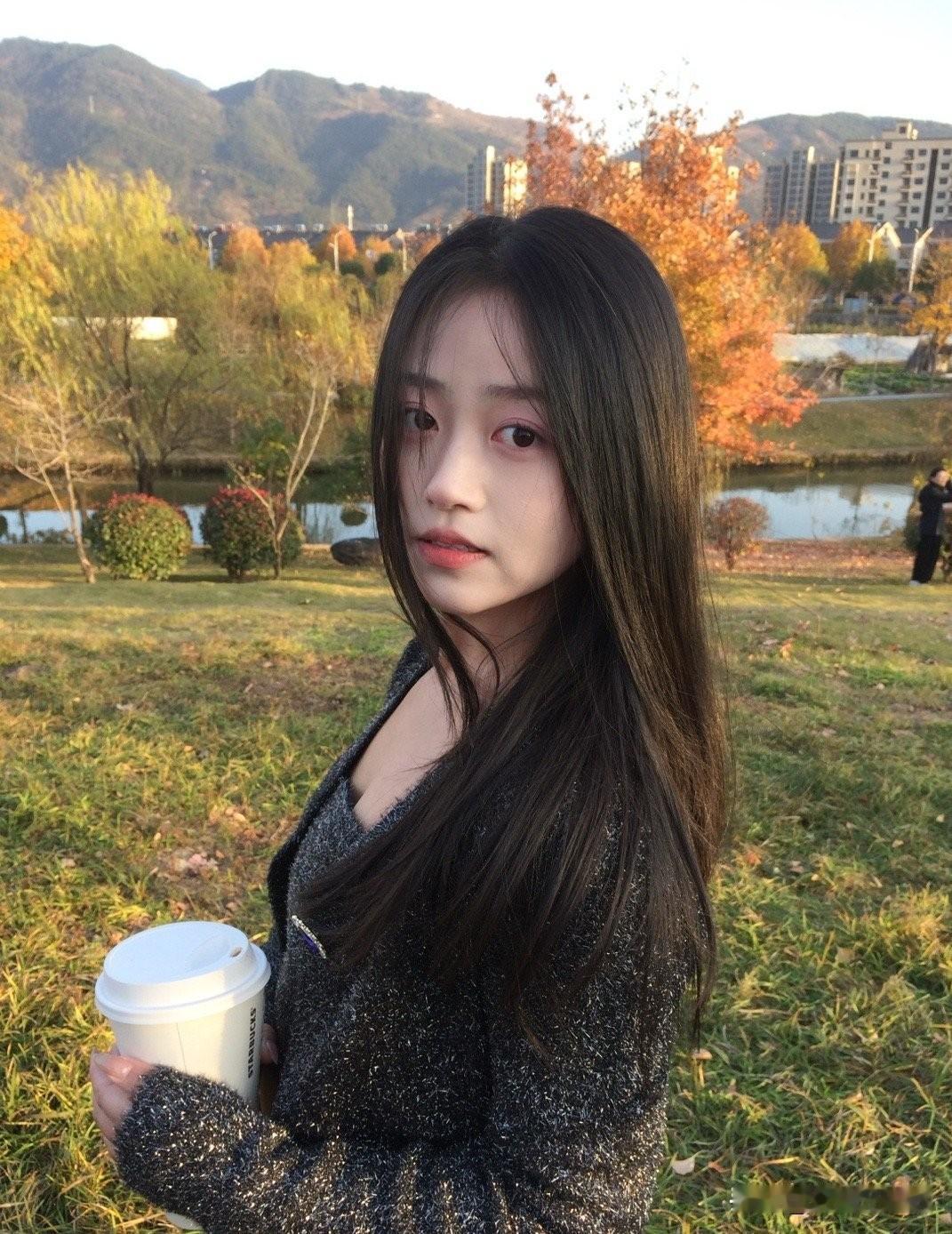 秋日暖阳下的少女，手捧咖啡，静享时光。