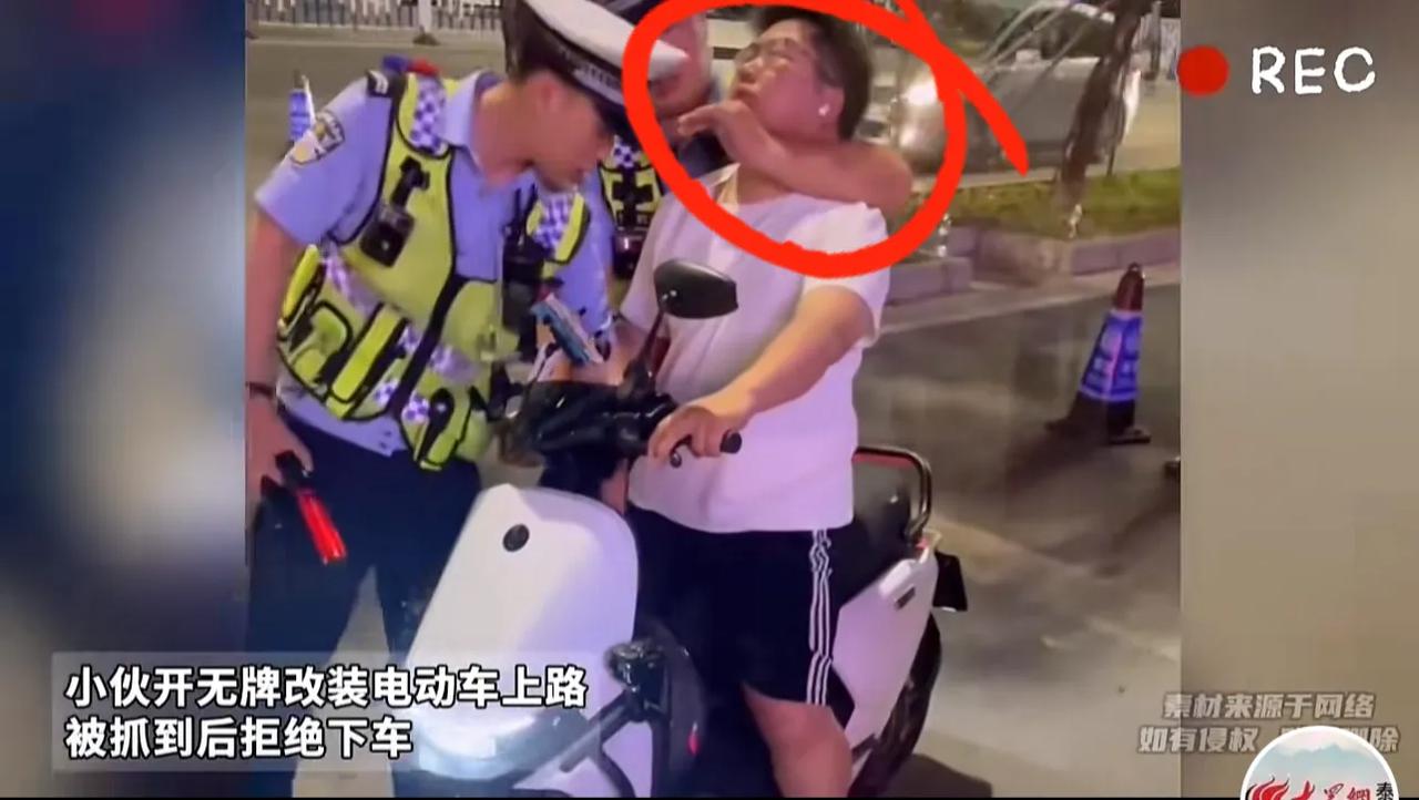 小伙子因为骑无牌电动车上路被警察锁喉。视频中一个骑电动车的小伙子被警察拦了下来，