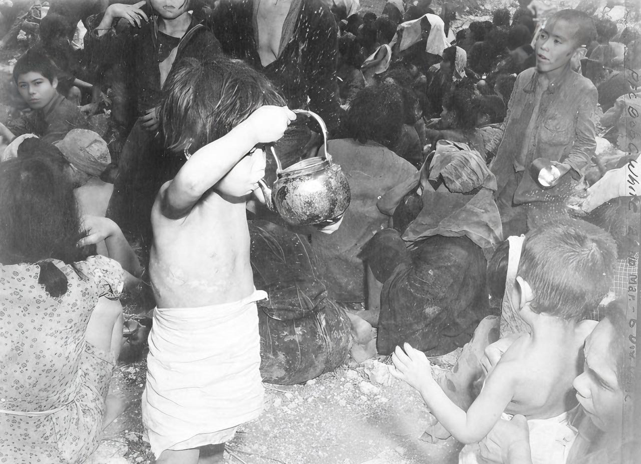1945年冲绳岛战役，美军摄影师发现了躲在洞穴中的平民。

其中一张照片，记录了