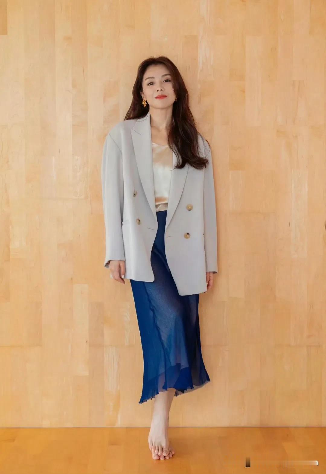 刘涛浅色系外套搭配深蓝色半裙，简约又不失优雅