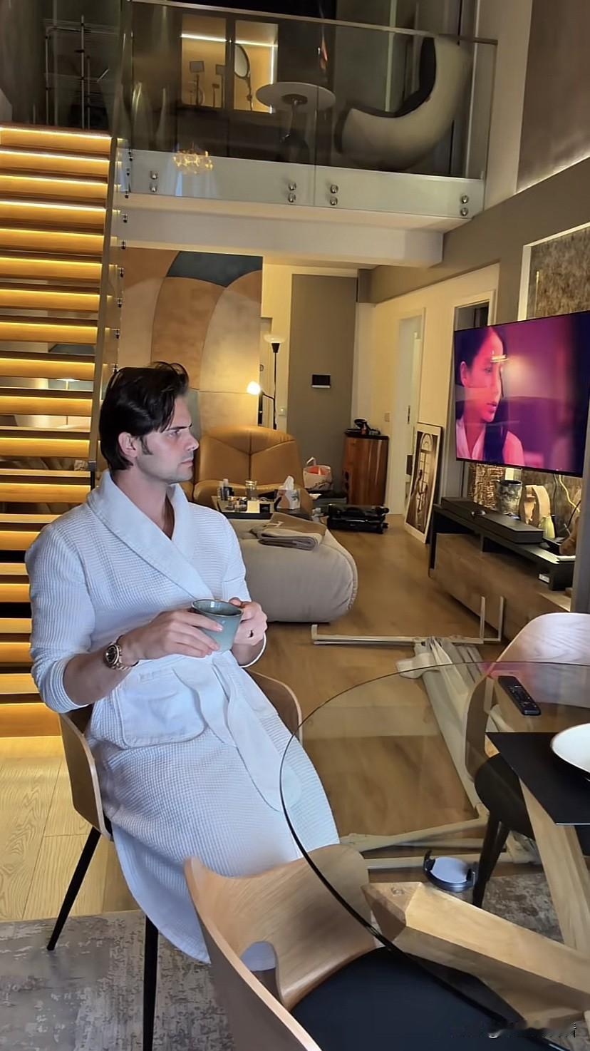 阿迪独自一个人在罗马尼亚的家里喝着咖啡，静静地发呆，电视开着没看，想了一会，把跟