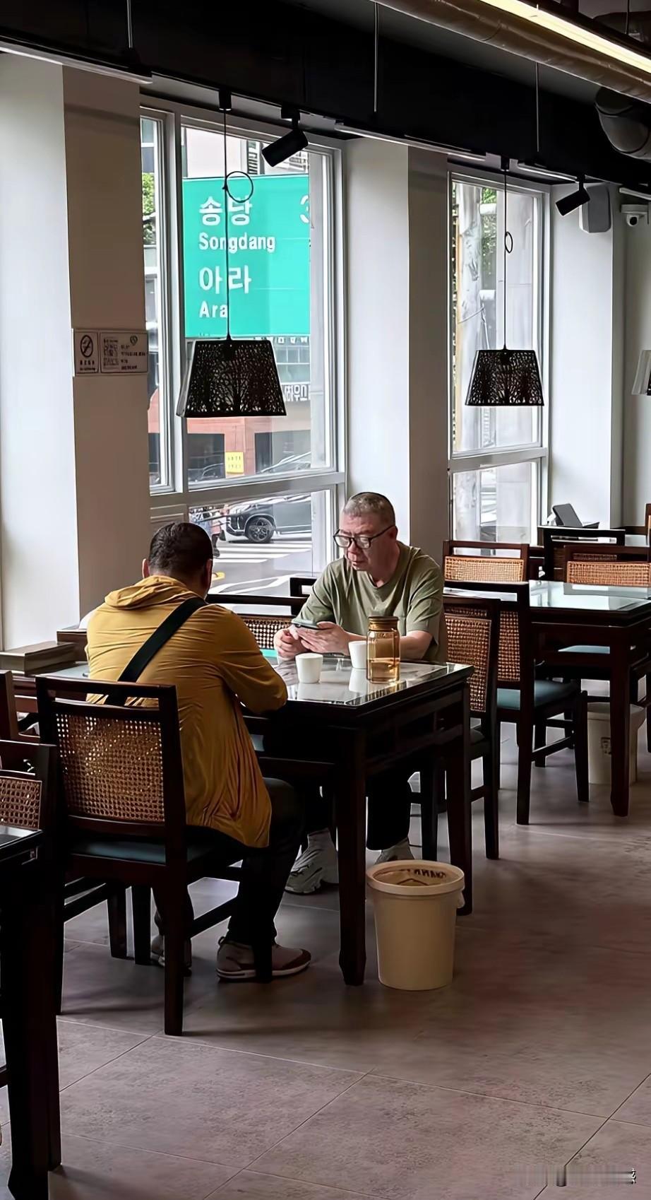 据说这是冯小刚近日在韩国旅游时的画面被网友拍到了，画面中的他，正在和一个韩国粉丝