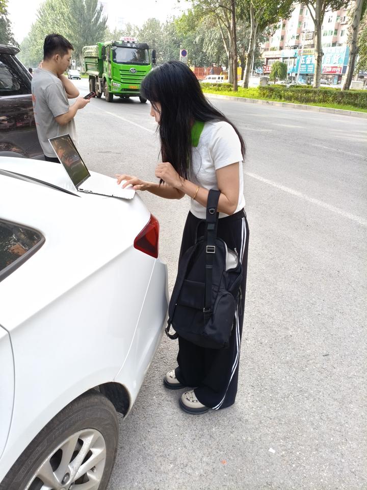 沈阳AI用户增多！路过街边撞见一幕很有现实感的画面，女生靠在车尾专心操作笔记本，