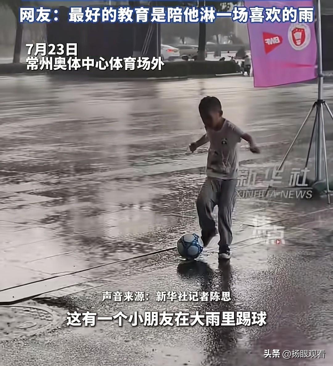 近日，常州奥体中心体育场外，小男孩雨中踢球，身边有爸爸陪伴，我觉得常州奥体中心这