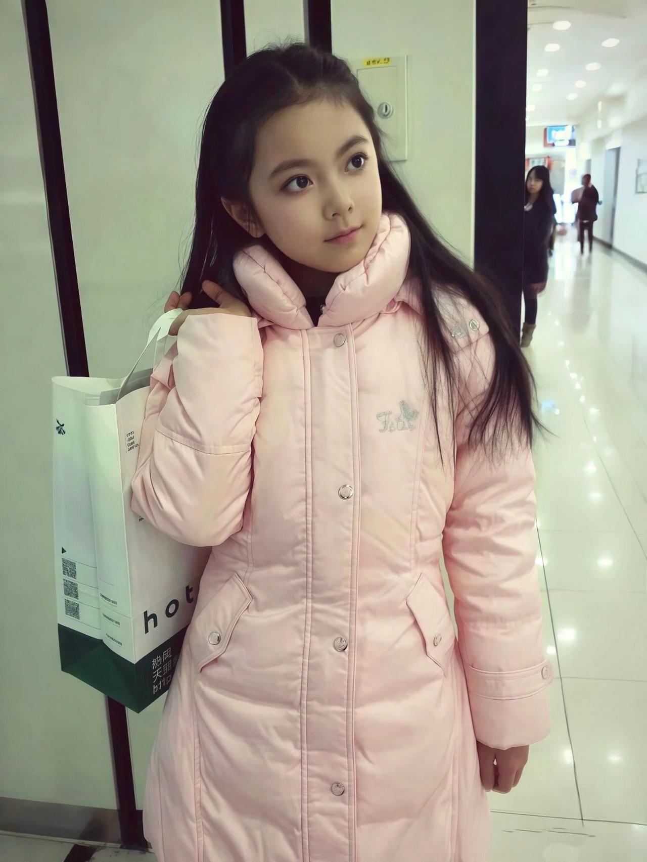 条友们，你能一眼看出这是哪位明星小时候的照片吗？
照片上的小女孩身穿粉色羽绒服，