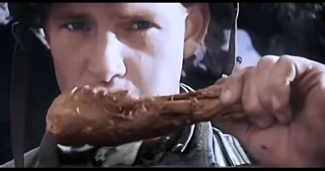 朝鲜战争时期美国大兵一边吃鸡腿一边看着摄像镜头。而我们的志愿军战士则是“一把炒面