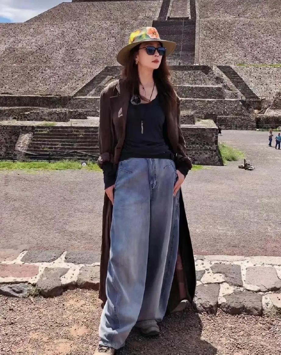谁被殷桃这组旅行图惊艳到了？
复古长风衣搭配阔腿牛仔裤，宽檐帽点缀，随性又大气。