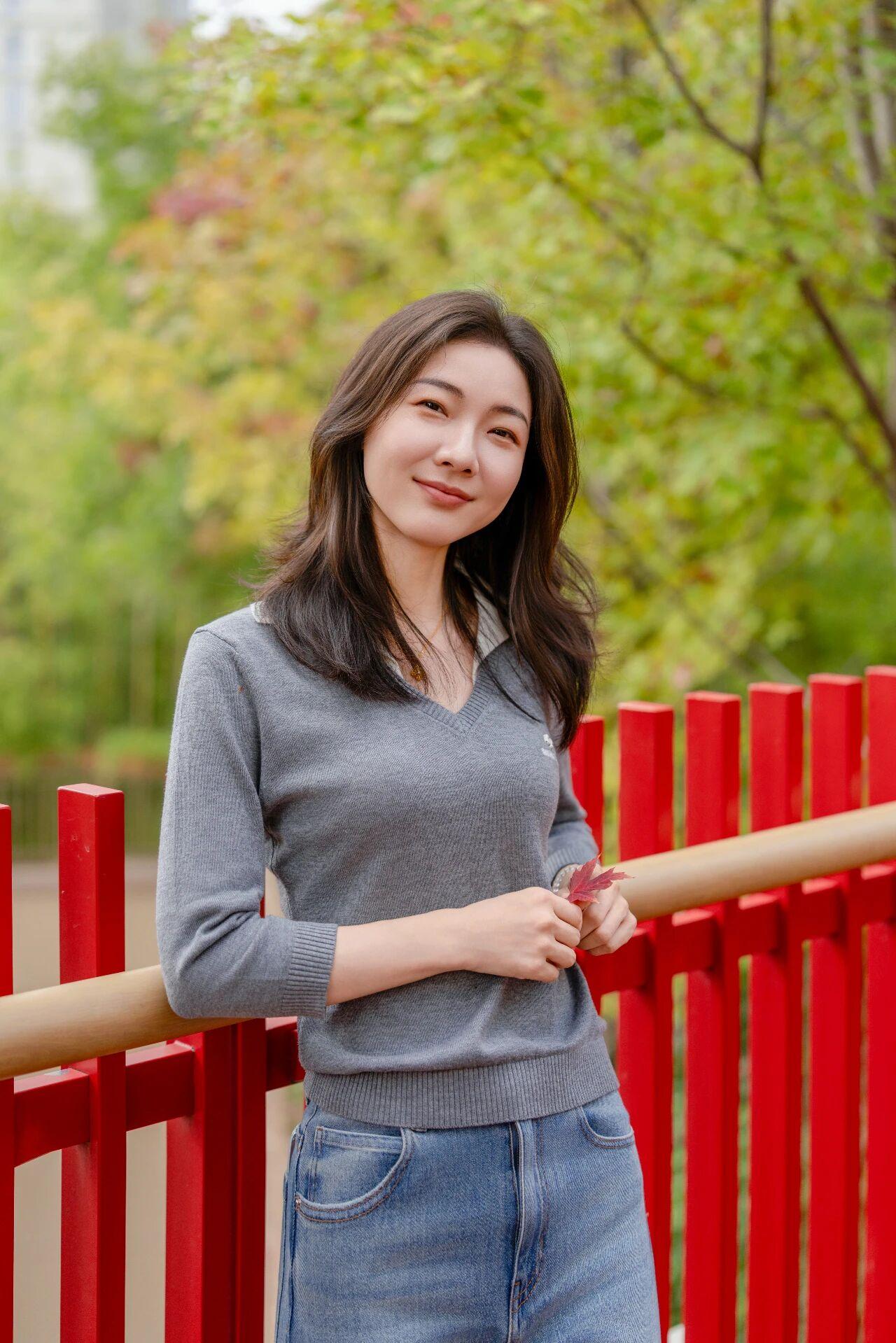 秋日暖阳下，微笑女孩与红木栏杆的浪漫邂逅。🍂🌸💕牛仔裤穿搭风格，配上女孩的