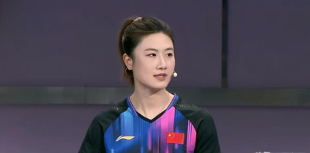 丁宁穿拖鞋蹲在球台边，手把手教娃发球。
王皓在旁边看，没说话，嘴角有点笑。
王楚