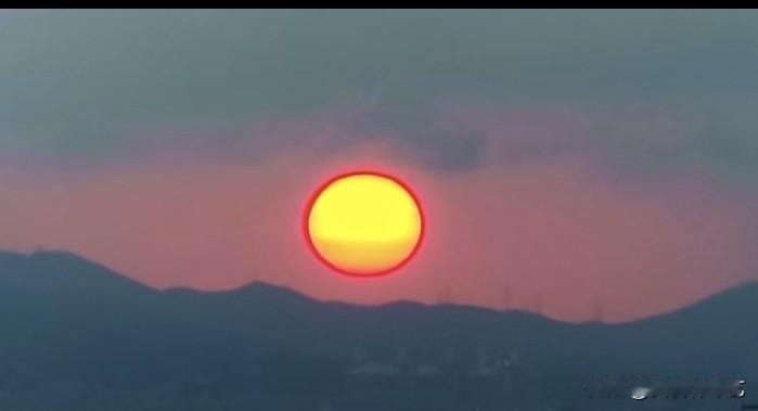 秋日生活打卡季一轮圆日悬于远山之上，暖黄霞光晕染天际，粉橙交织。层叠山峦化作静谧
