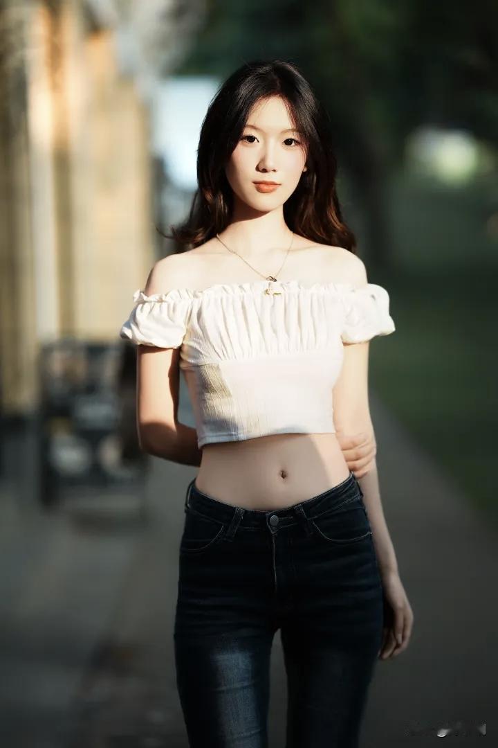 晚照斜穿巷陌长，风轻拂鬓影清扬。
素衣露肩凝玉骨，墨裤修身衬柳腰。
眸底星沉秋水