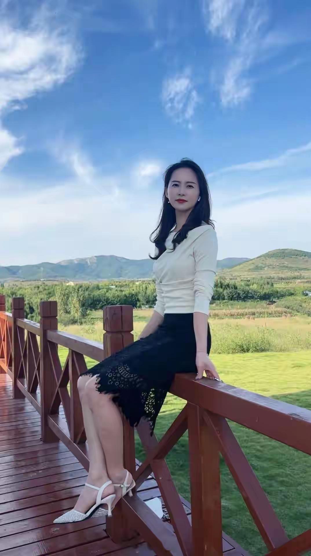 她坐在木桥上，风景真美。