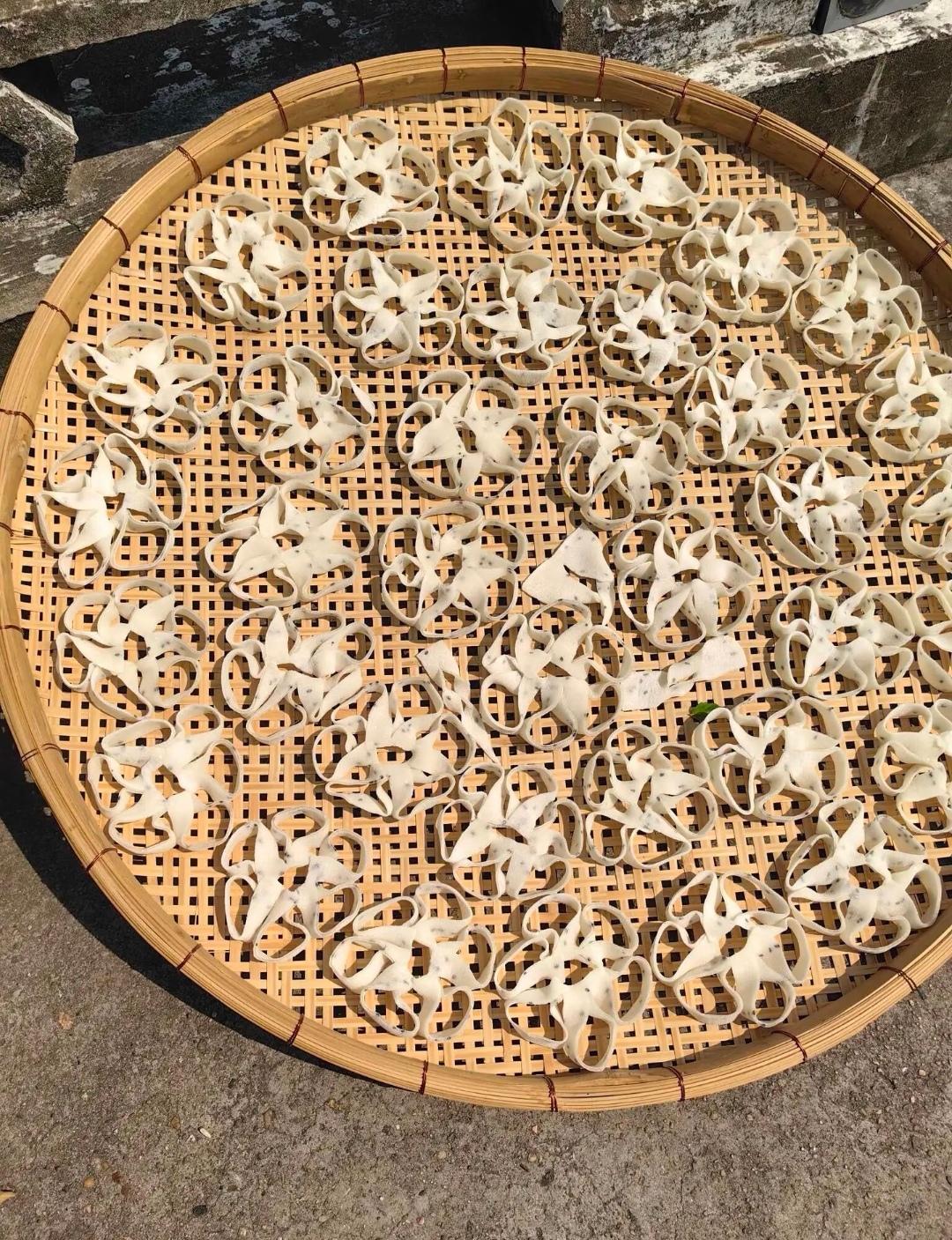 路边偶遇晒在竹簸箕里的小吃，造型像一朵朵小白花。
有谁认识这个？看着像面食，晒好