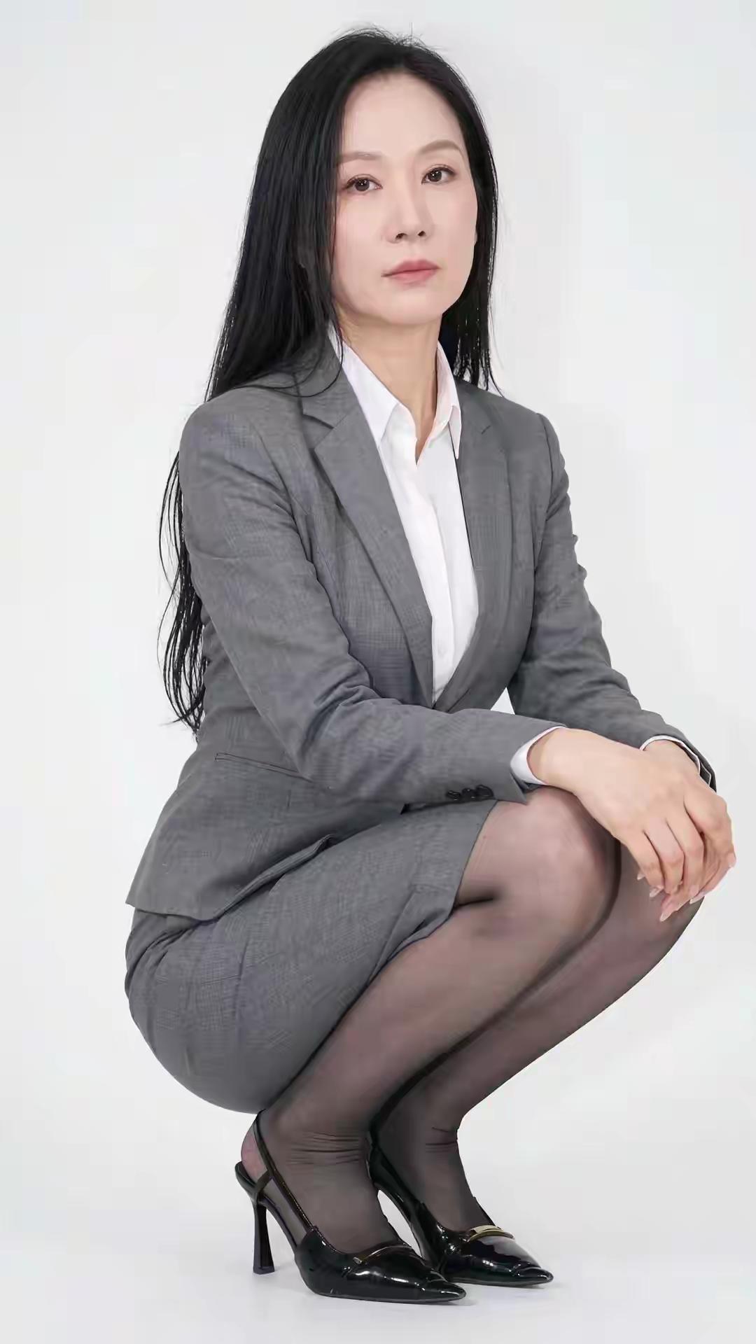一身经典的灰色西装套裙，白衬衫做内搭，简约又很有力量感。利落的剪裁，沉稳的气质，