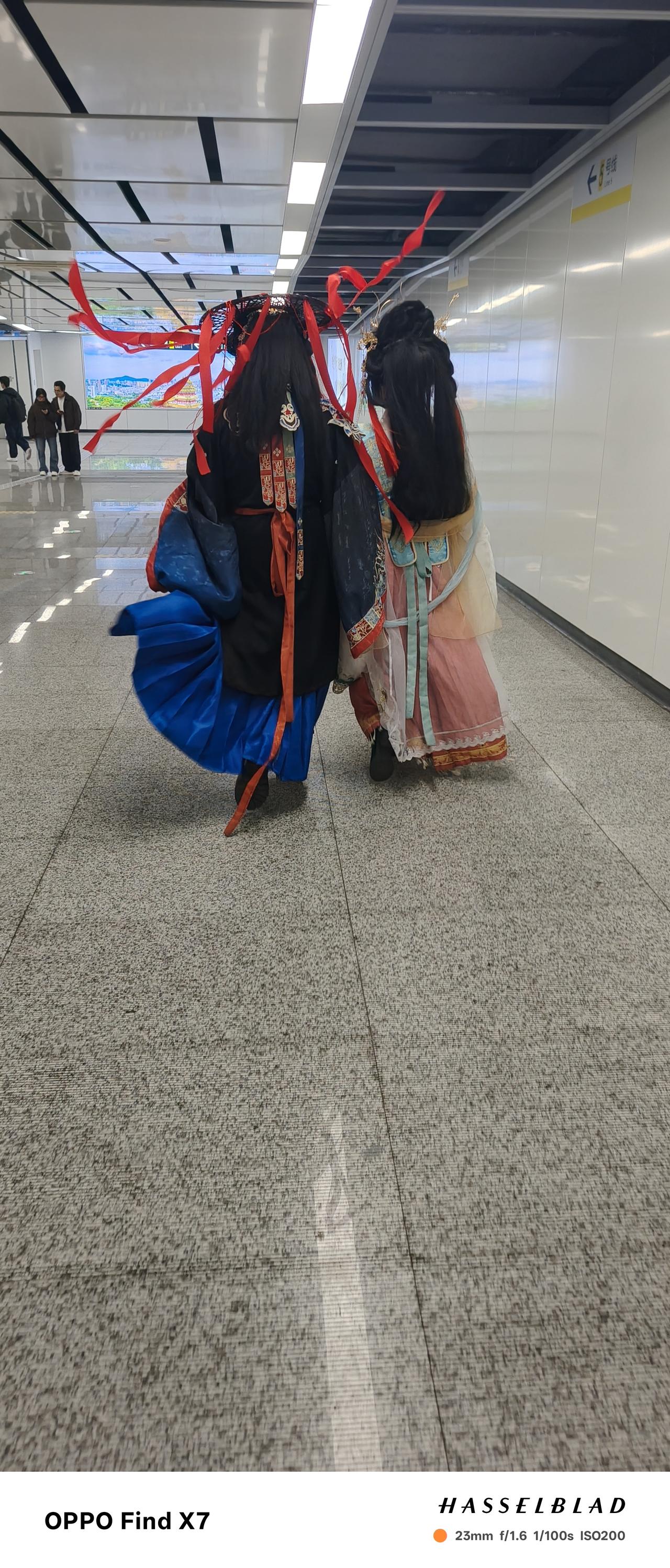 南京的第一天，在地铁口看到两个古装女孩，头上飘逸的红丝带让人挺难接受，这民俗与古