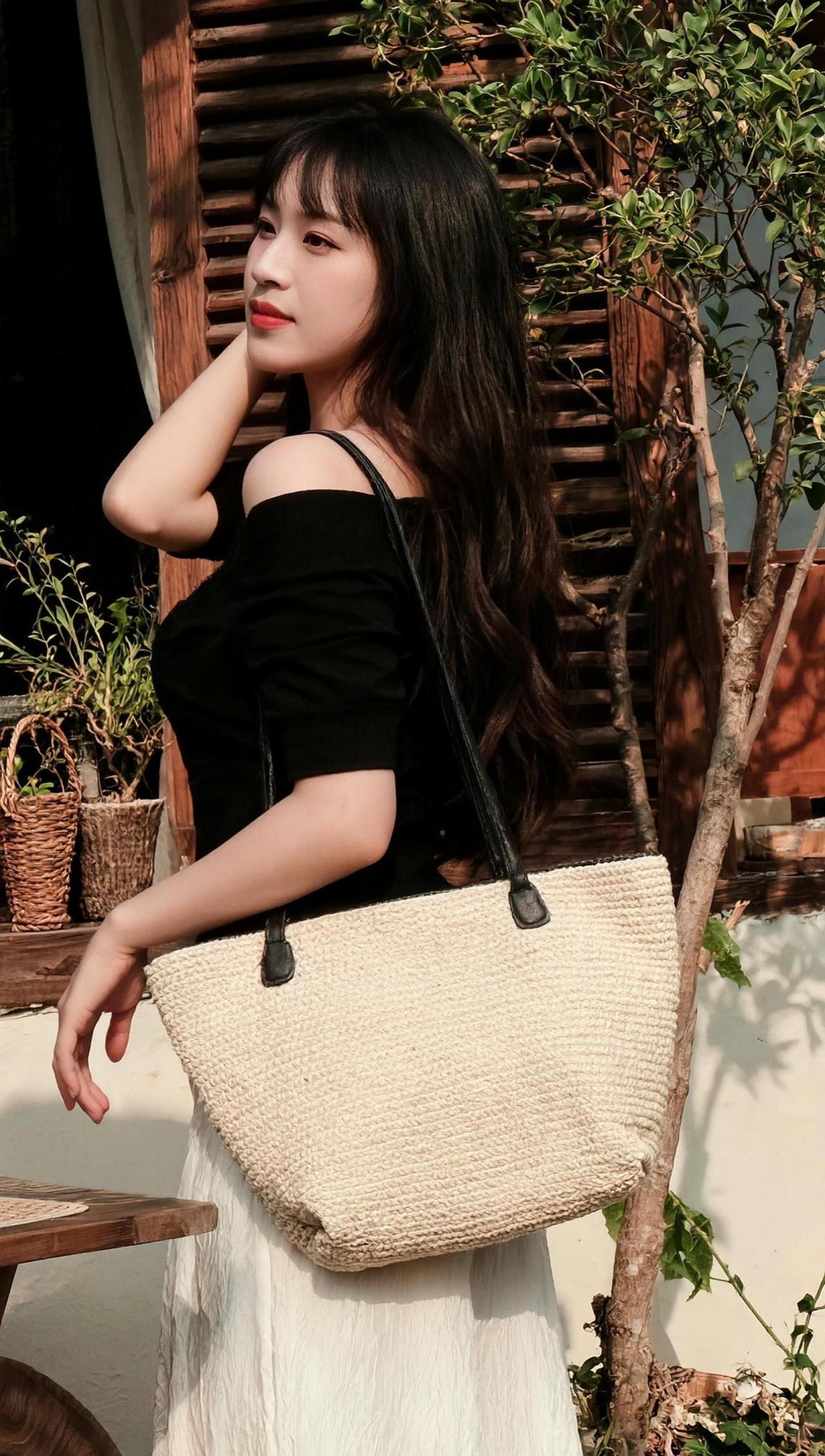 在绿意盎然的背景下，一位女孩静静站立，仿佛与自然融为一体。阳光透过树叶的缝隙，洒