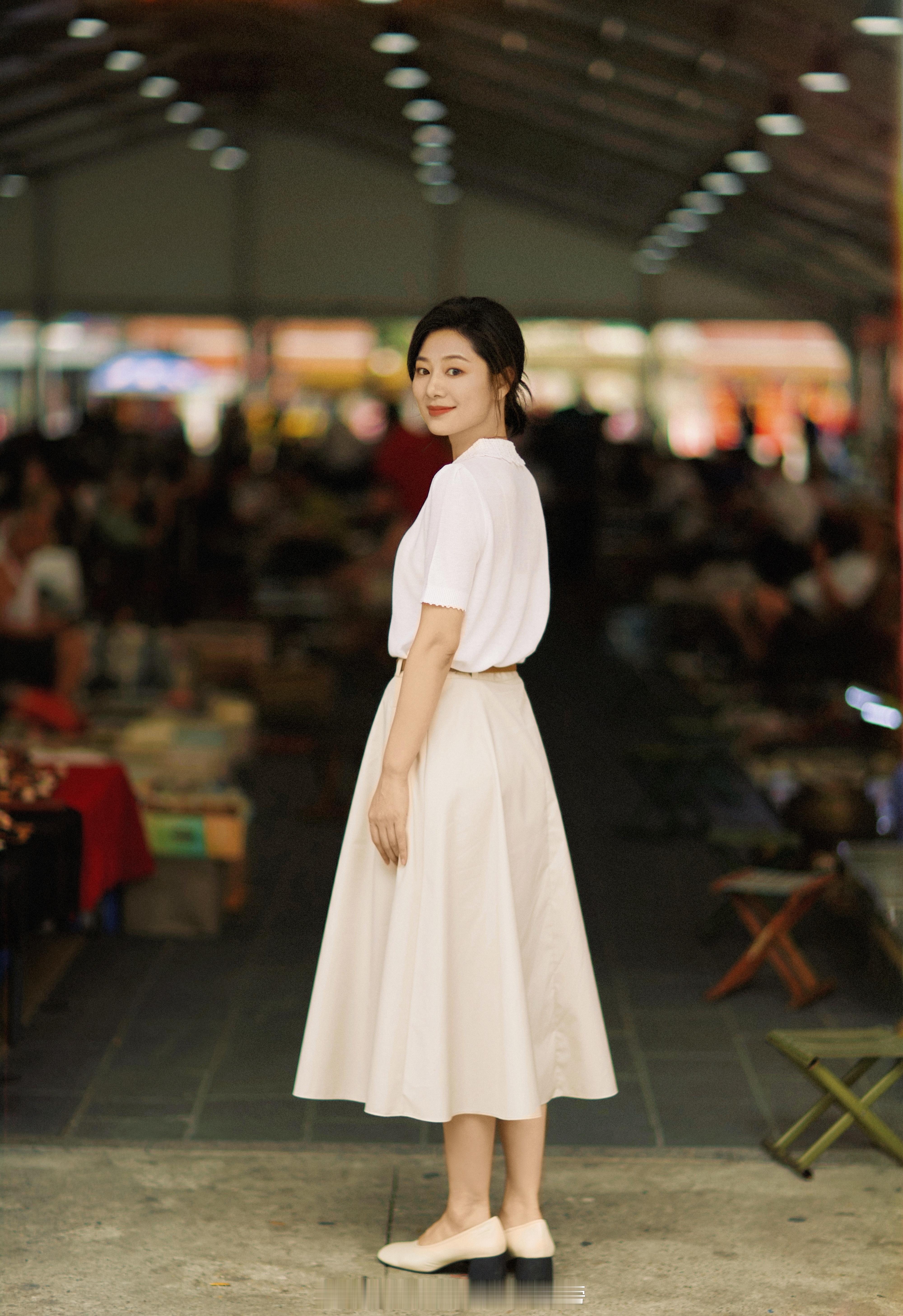 演员王真儿，蕾丝娃娃领的白色短袖针织衫，搭配卡其色高腰半身长裙和浅口粗跟鞋，整体