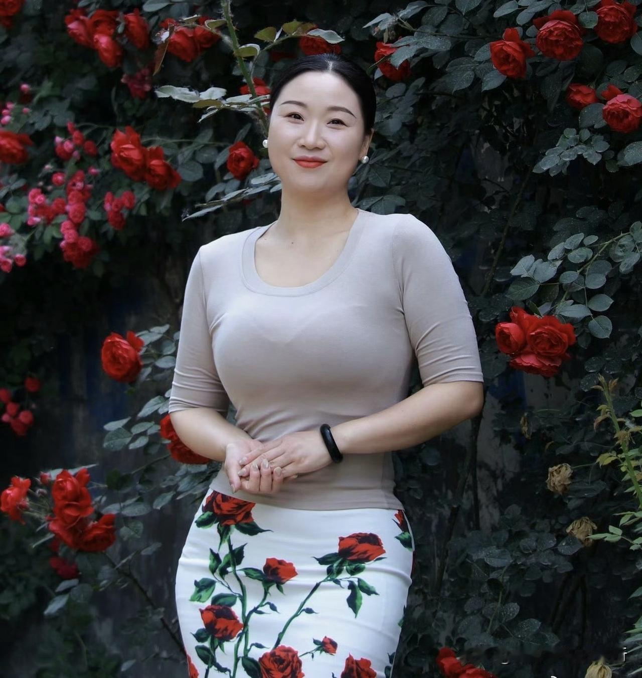 裙上玫瑰与墙畔花影相拥，把夏的热烈与温柔，都织进了这帧鲜活的画里。
棕衫衬着从容