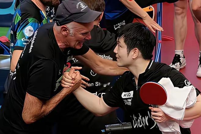 樊振东在德国打完比赛后，没急着回休息室，而是径直走向观众席前排。一位头发花白的德