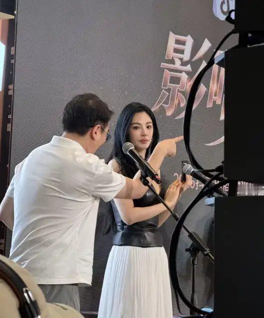张雨绮身穿黑色抹胸上衣搭配白色长裙icon，一头卷发披肩，整个人高挑消瘦出现在活