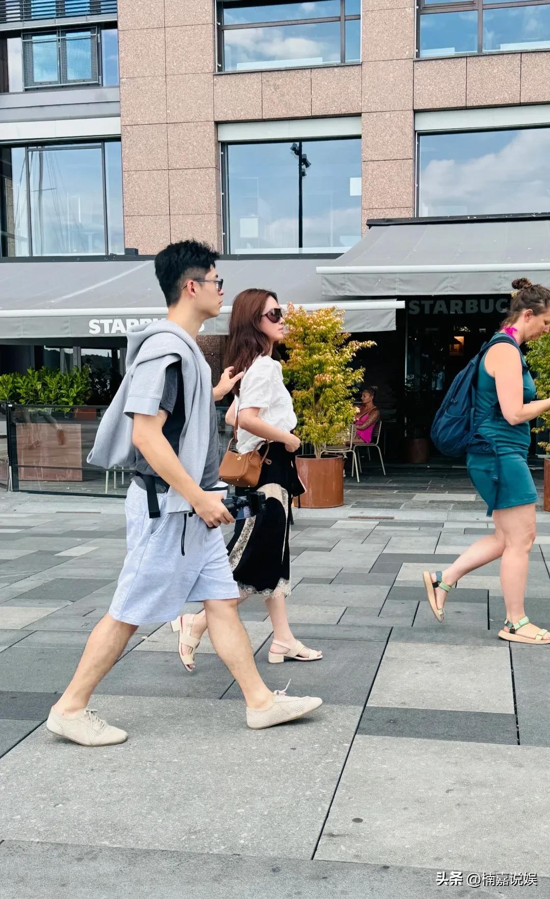 杨采钰和老公现身挪威旅游，夫妻俩罕见同框。
卷发披肩的杨采钰，戴着墨镜，穿着白色