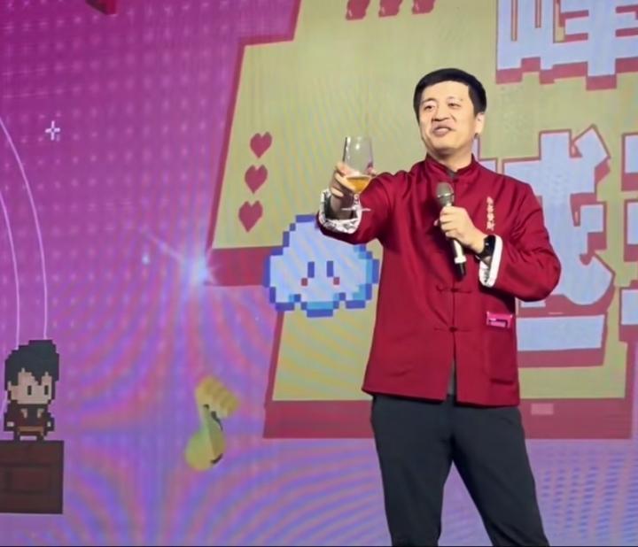 2024峰学蔚来年会上，酒精过敏的张雪峰举着酒杯，对着台下001号万霞、002号