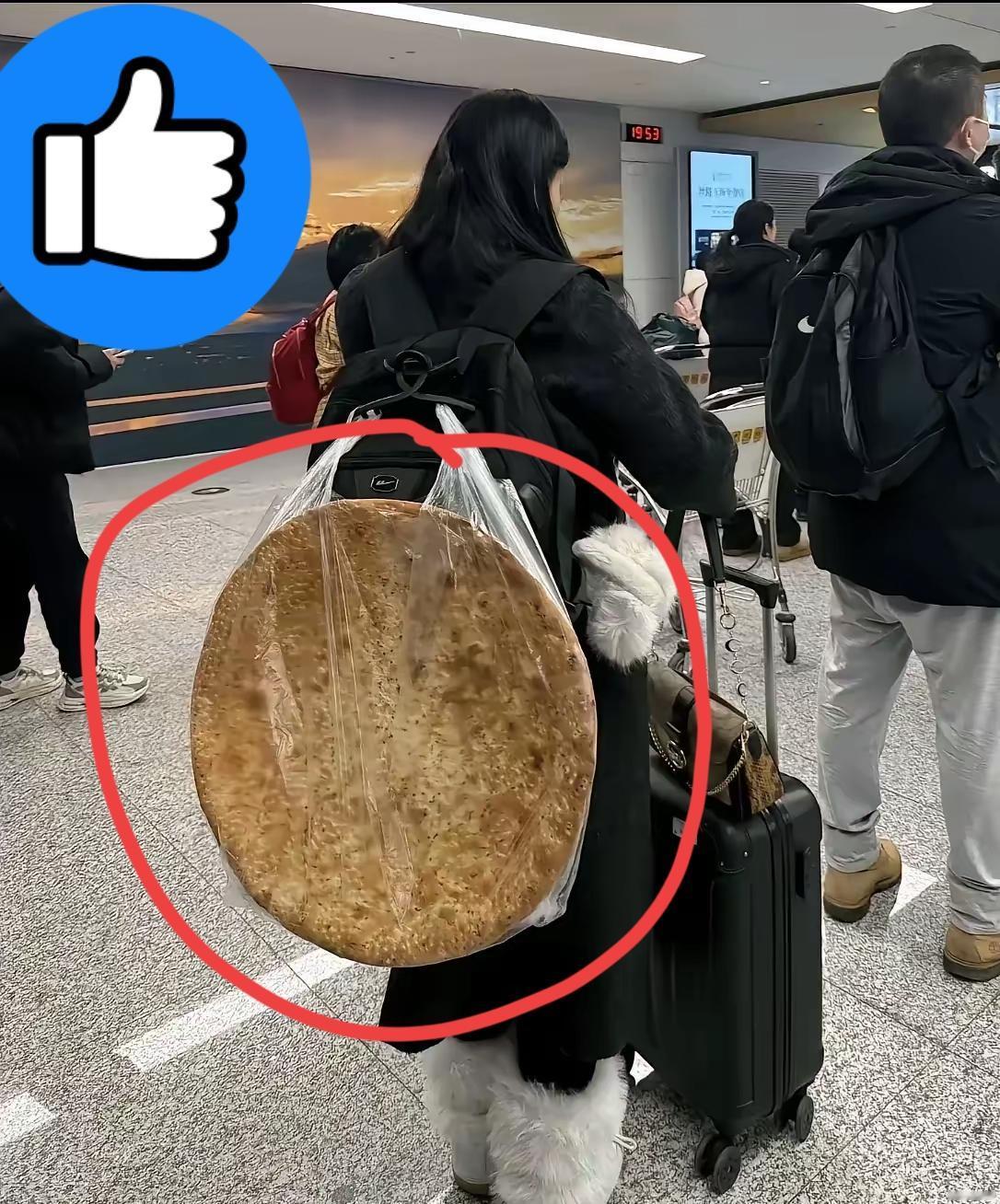 今日机场奇遇：见过带特产的，没见过背“巨型馕”赶飞机的！这块馕比小姐姐的肩还宽，