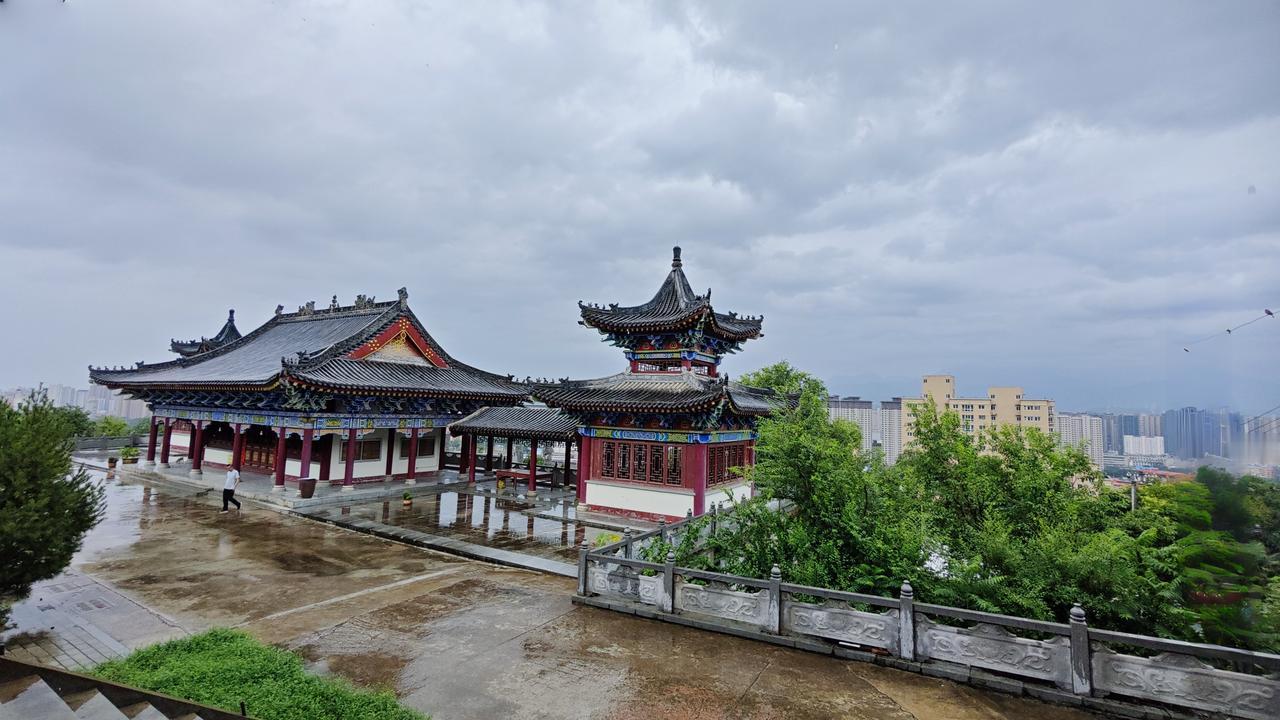 这张照片是昨天和家人去朝峰寺拍的。当时天还下着雨，雨中的楼阁气势磅礴。这个寺院的