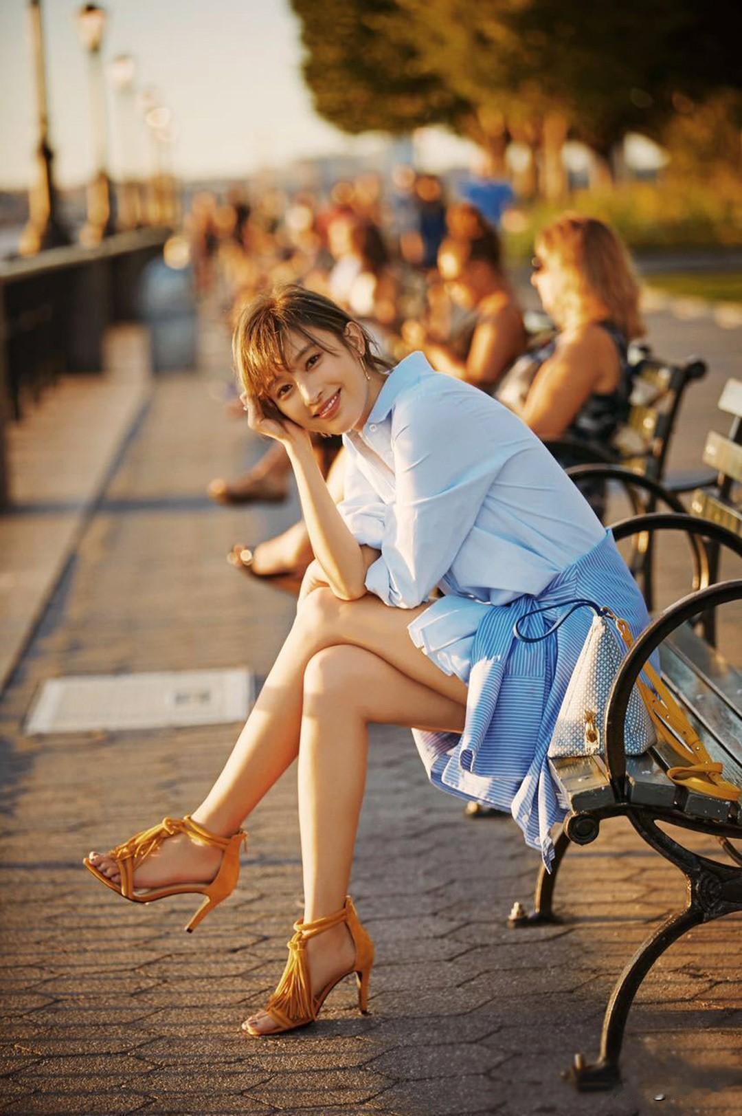 阳光下的午后，甜美少女在公园长椅上微笑。