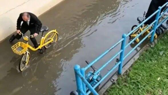 此前暴雨天气，一位穿搭整洁的西装爷叔骑行途经上海地铁9号线漕河泾开发区站旁便民非