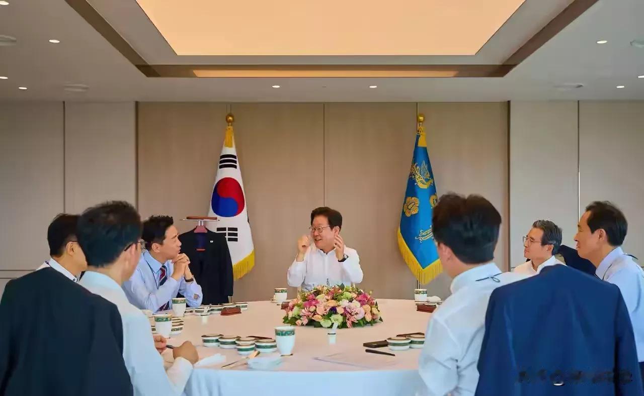 总统吃饭也是公事，李在明坐在主位，背后放置着韩国国旗及总统府旗，如同在内阁召开会