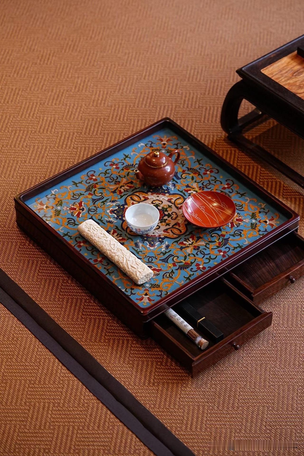 大红酸枝的沉稳，与景泰蓝的绚丽，在这一方都承盘上相遇。

缠枝莲纹层层舒展，繁而