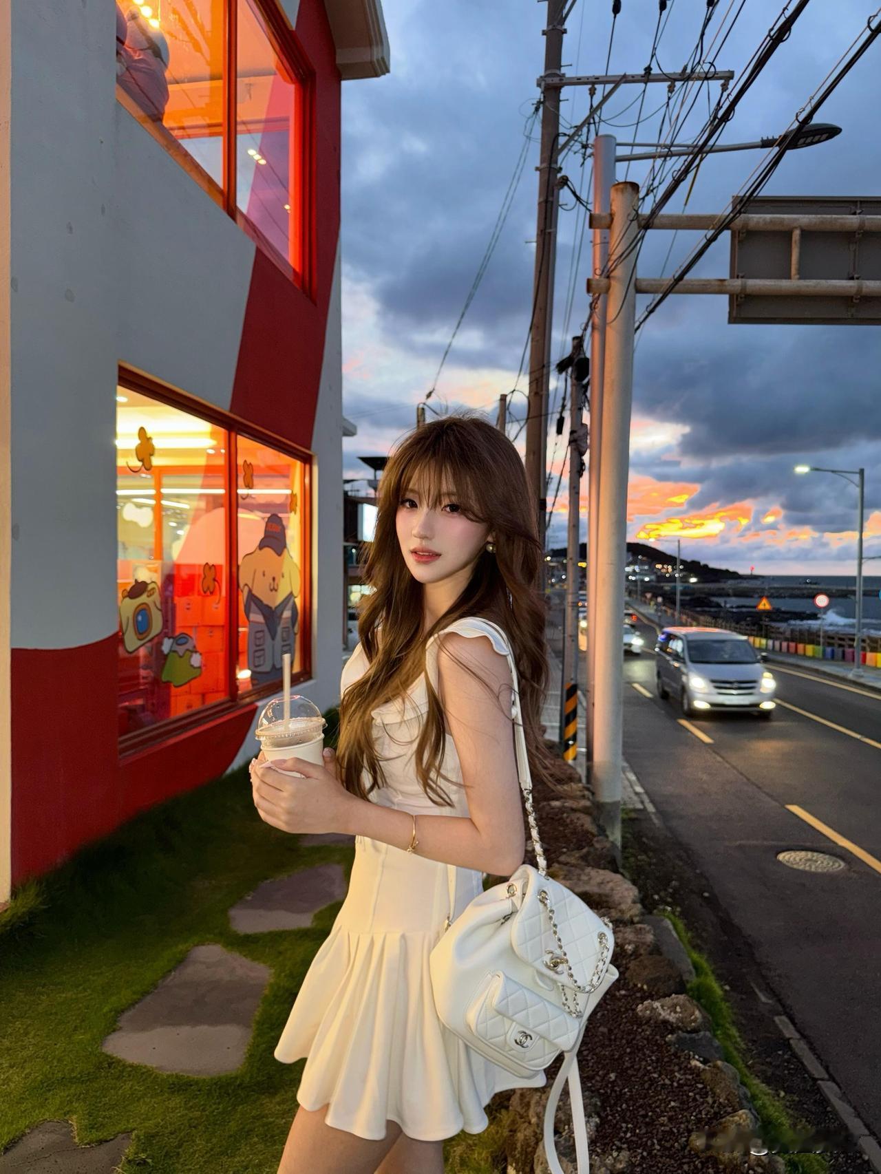 夏日黄昏，少女漫步在街角，手持奶茶，享受宁静时光。