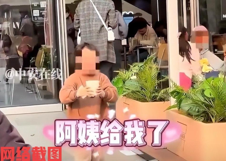 浙江绍兴某奶茶店门前，有小女孩手拿刚刚向店员要的一杯温水，小心翼翼朝着自己妈妈这