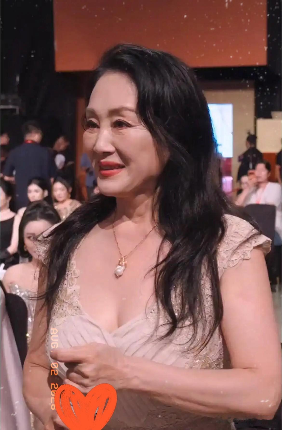 金鸡奖红毯上，
64岁的王姬穿了条黑色亮面鱼尾裙，
因为侧边开叉，结果肚子上一道