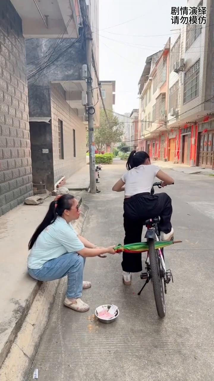 女子骑车走时被旁边假盲人整蛊，这一幕真的太搞笑了。
女子准备骑自行车走，谁知旁边