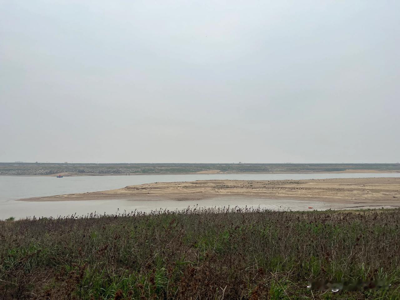 灰调水墨画般的湿地舒展在眼前，远处的水纹咬住低垂的天幕，吞没了所有喧嚣。云层正酝